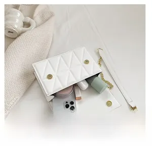 Interior view of white quilted crossbody bag showing storage for phone and cosmetics