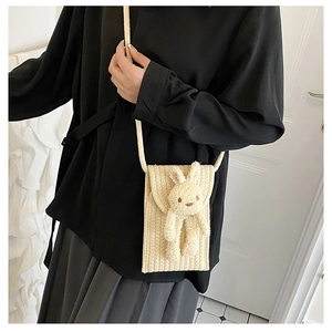 Détail du sac de téléphone en coton tressé beige avec décor de lapin en peluche 3D