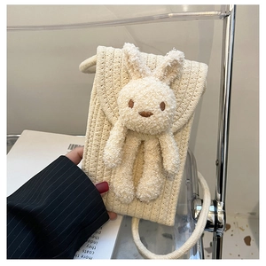 Détail du mini sac tissé crème avec un lapin en peluche 3D et une bandoulière tressée