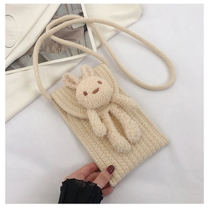 Vue macro d'un sac de téléphone en coton beige fait main avec décor de lapin peluche