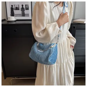 Détail du sac bandoulière en nylon bleu clair avec tissu plissé et chaîne en perles