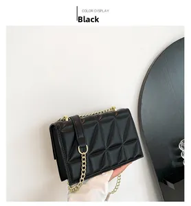 Detail of black quilted crossbody bag showing triangular pattern and gold chain strap