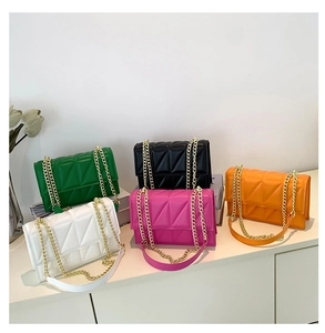 Close-up of quilted candy-colored crossbody bags with gold metal chain straps
