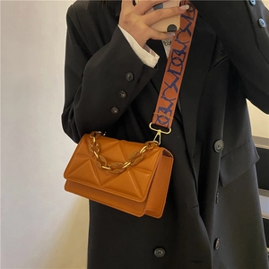 Quilted geometric pattern crossbody bag with orange leather and decorative resin chain