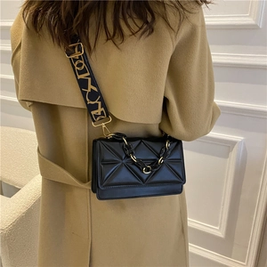 Chic black quilted crossbody bag with wide blue shoulder strap and gold chain detail