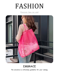Detalle del bolso tote de malla rosa que muestra la tela transpirable y el diseño amplio
