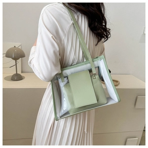 Detailed view of transparent PVC tote bag with sage green inner pouch and long shoulder strap