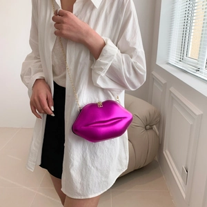 Sac à bandoulière en forme de lèvres magenta métallisé avec chaîne dorée sur mannequin