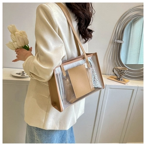 Detailed view of clear PVC tote bag featuring a beige leather inner pouch and shoulder strap