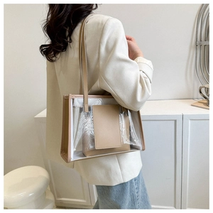 Close-up of a clear PVC tote bag with leather trim and matching inner pouch