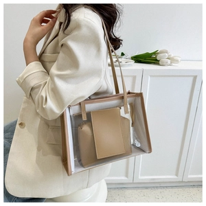 Detailed side view of clear PVC tote bag with beige leather inner pouch on shoulder