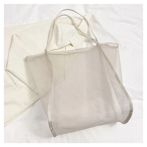 Detalle del bolso tote de malla blanca con textura de nailon y costura inferior reforzada