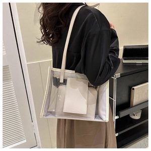Detail view of transparent PVC tote bag with cream leather trim and inner pouch