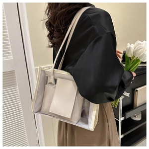 Detail of transparent PVC tote bag with white inner pouch shown in soft home setting