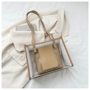 Detailed view of transparent PVC tote bag and brown leather inner pouch on suit jacket