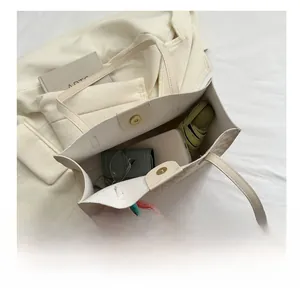 Top view of cream canvas tote bag showing spacious interior with metal magnetic closure