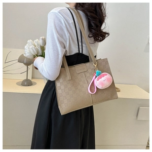 Detail of light brown large tote bag with checkered texture and fashion engraving