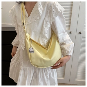 Pale yellow nylon hobo bag featuring a white cloud charm and adjustable crossbody strap