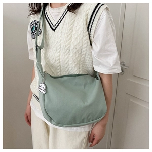 Detail of mint green corduroy crossbody bag with soft texture and cute plush charm