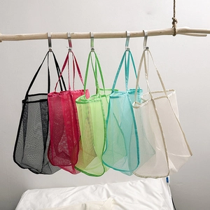 Mesh shopping tote bag for women in five colors hanging on a wooden beam