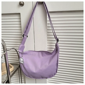 Detail of light purple corduroy crescent bag featuring soft texture and cloud charm