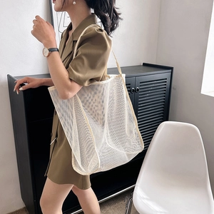 Bolso tote de malla blanca con neceser de leopardo llevado por una modelo de moda