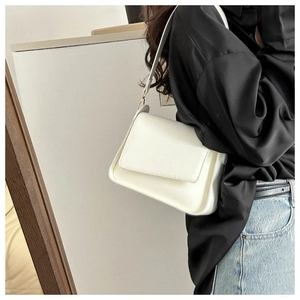 Chic white rectangular leather shoulder bag styled with a black shirt and blue jeans