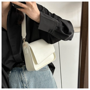 Mirror selfie showing the white leather crossbody bag with a wide strap on a person