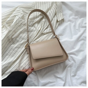 Minimalist beige PU leather shoulder bag shown against a striped fabric background