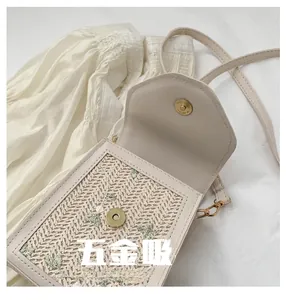 Detail of floral embroidery on lace woven bag with magnetic golden buckle closure