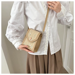Mini straw crossbody bag with leather trim shown on model for a rustic summer look