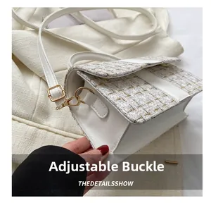 Detail of adjustable metal buckle and textured tweed material on white crossbody bag