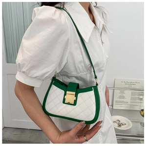 Detail of green and white color-block handbag with diamond quilted texture and gold lock
