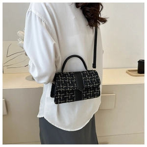 Model view of black and white tweed crossbody bag with elegant leather handles