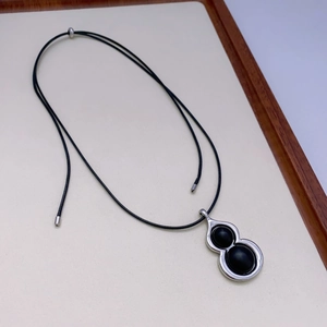 Collier ethnique avec pendentif gourde en ébène, détails argentés et cordon noir