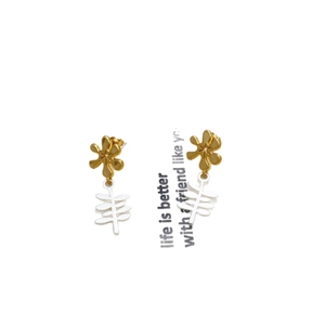 Fashionable floral earrings with matte gold petals and white leaf pendants on a white card