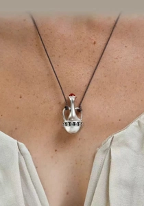 Close-up of vintage amphora vase pendant with red agate stone on brown cord necklace