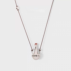 Macro detail of amphora pendant necklace with red agate stone and gold-plated finish