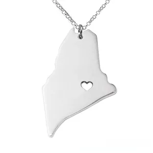 Detailed macro view of Maine state map necklace with hollow heart cutout on silver chain