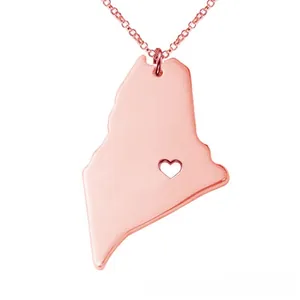 Macro view of rose gold Maine state map pendant with a delicate hollow heart detail