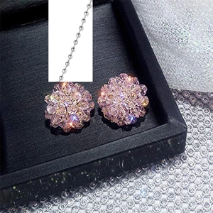 Detail van roze kristallen bloemoorstekers met bijpassende zilveren kralenketting