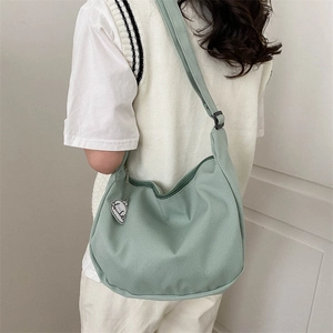 Minimalist mint green nylon crossbody bag with crescent moon shape and cloud charm