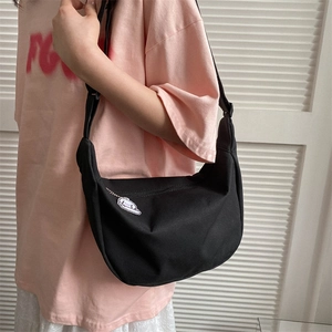 Minimalist black nylon hobo crossbody bag with a cute white cartoon charm detail