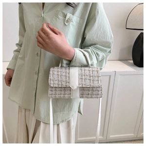 Detailed view of tweed fabric texture and white leather trim on a classic crossbody bag