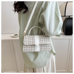 Detailed view of a tweed plaid square bag worn crossbody on a female model