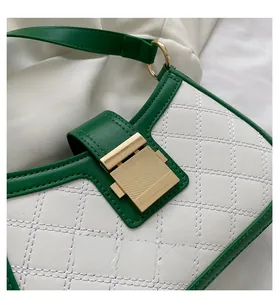 Detail of green and white leather bag with diamond quilting and gold metal lock