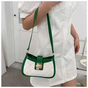 Detail of green and white quilted crossbody bag with golden rectangular lock