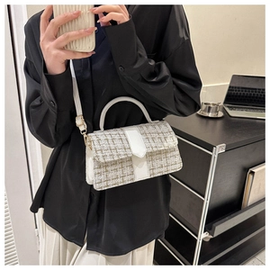 Detail of tweed crossbody bag featuring beige weave texture and white leather shoulder strap