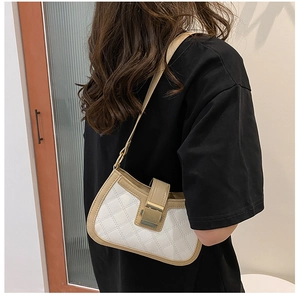 Detailed view of women's colorblock shoulder bag with white quilting and khaki strap