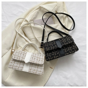 Detail of tweed checkered crossbody bags in cream and black on a stylish blazer